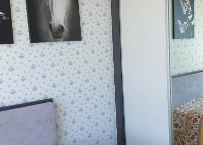 Bedroom with patterned wallpaper, single bed, and sliding door wardrobe