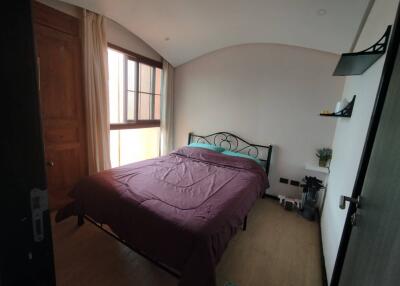 Cozy bedroom with natural light and wooden flooring