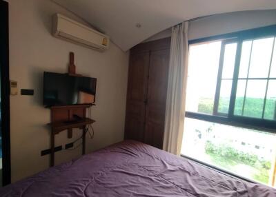 Spacious bedroom with air conditioner, TV, and large window