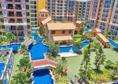 Aerial view of a colorful apartment complex with landscaped gardens and water features