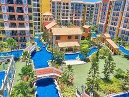 Aerial view of a colorful apartment complex with landscaped gardens and water features