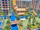 Aerial view of a colorful apartment complex with landscaped gardens and water features