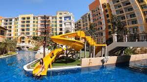 Exterior view of apartment complex with pool and water slide