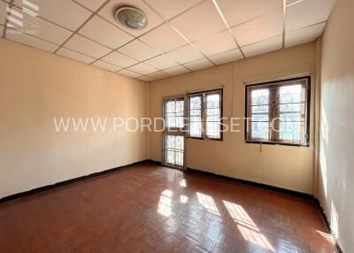 Empty room with tiled ceiling and windows