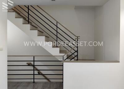 Modern staircase and landing area with black metal railings and wooden steps