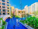 View of residential buildings with a swimming pool and lush landscaping.