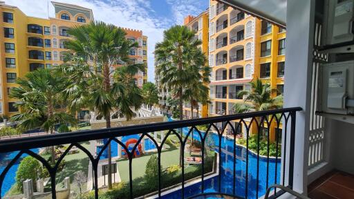 View from balcony overlooking residential complex with pool and palm trees