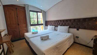 Well-lit bedroom with two single beds