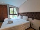 Bedroom with two beds, a window, and wooden wardrobe