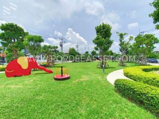 Community playground with green grass and playground equipment