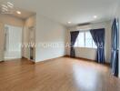 Spacious living room with wooden flooring and large windows