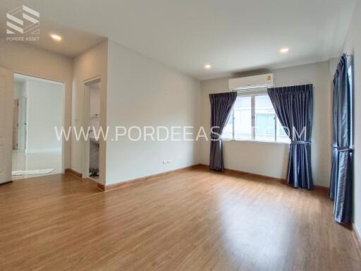 Spacious living room with wooden flooring and large windows