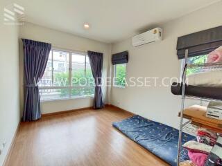 Bright and airy bedroom with large window, wooden flooring, and air conditioning.