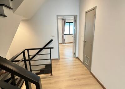 Modern hallway with wooden flooring and metal staircase