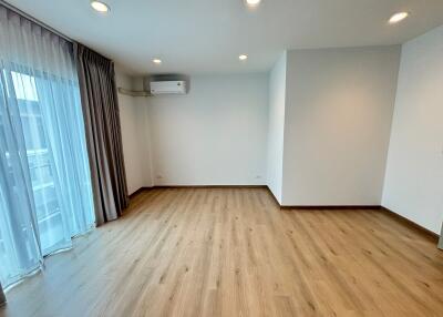 Spacious living room with wooden flooring and large windows