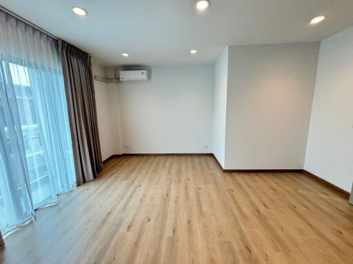 Spacious living room with wooden flooring and large windows