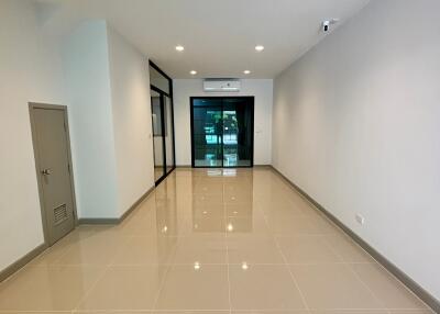 Spacious main living area with tiled floor, recessed lighting, and glass door