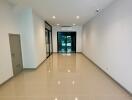 Spacious main living area with tiled floor, recessed lighting, and glass door