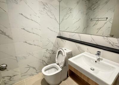 Modern bathroom with sink, toilet, and large mirror