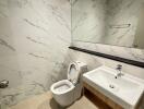 Modern bathroom with sink, toilet, and large mirror