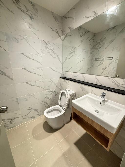 Modern bathroom with sink, toilet, and large mirror