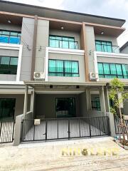 Front exterior of a modern townhouse with parking space