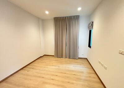 Empty bedroom with wooden floors and curtains