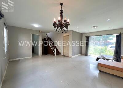 Spacious living room with chandelier and stairs