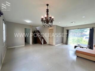 Spacious living room with chandelier and stairs