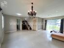 Spacious living room with chandelier and stairs