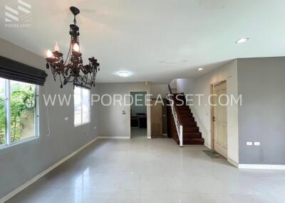 Spacious living area with chandelier and staircase