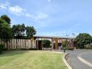 Entrance of a residential complex with well-maintained landscaping and clear skies