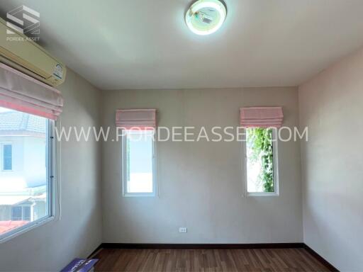 Bright bedroom with two windows and wooden flooring