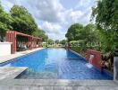 Outdoor swimming pool with water features and surrounding greenery