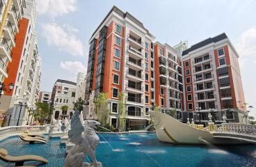 Facade of a modern residential complex with swimming pool and decorative statues