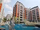 Facade of a modern residential complex with swimming pool and decorative statues