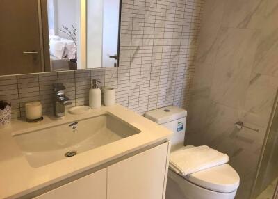 Modern bathroom with white sink, toilet, and shower