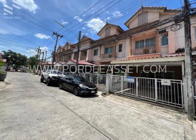 Street view of townhouses with cars parked outside