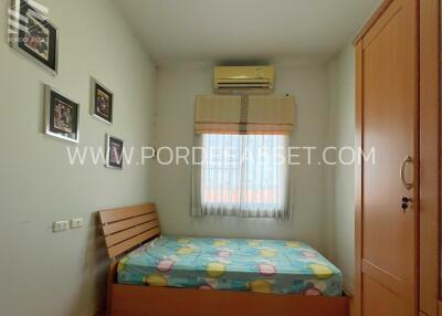 Small cozy bedroom with a single bed, air conditioner, window, and wooden wardrobe