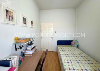 Cozy single bedroom with desk and wall decorations