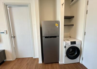 laundry area with washing machine and refrigerator