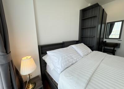 cozy bedroom with a double bed, lamp, and dark wood furniture