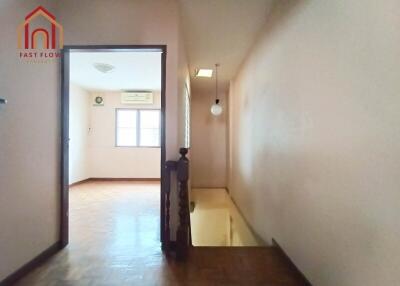 Hallway leading to a room with wooden floors