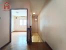 Hallway leading to a room with wooden floors