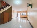 Spacious main living area with tiled flooring and stair access