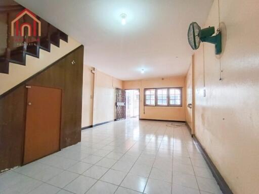 Spacious main living area with tiled flooring and stair access