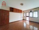 Spacious living room with wooden flooring and ample natural light