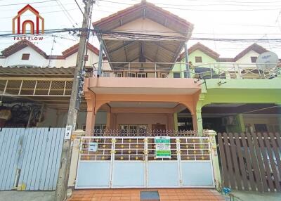 Front view of a multi-story house with a tiled roof and a gated entrance