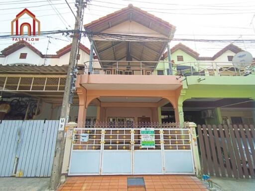 Front view of a multi-story house with a tiled roof and a gated entrance