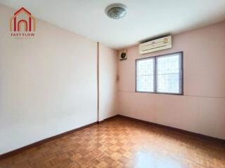 Empty bedroom with wooden floor and air conditioner